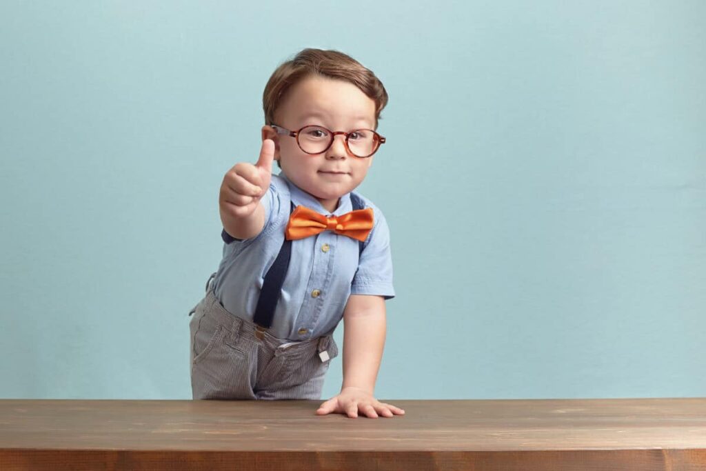 boy in bowtie and glasses gives positive thumbs up